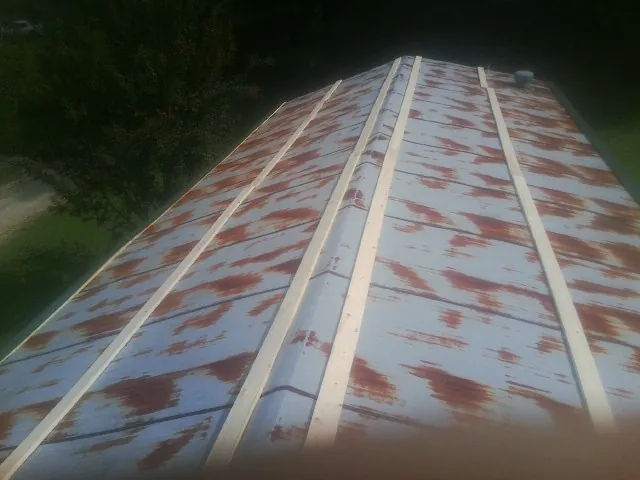 Rusted metal roof panels with new wood purlins before replacement — Storm Damage Roof Repair in Armuchee by Roofing Brothers