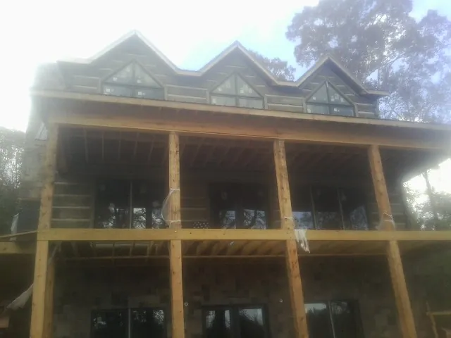 Dormers and porch framing on a large log home under construction — Roof Coating work by our crew in Armuchee