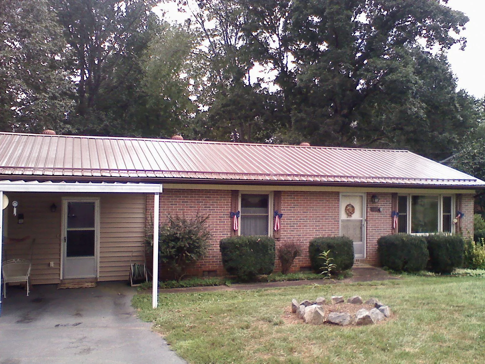 Bronze metal roof and carport on a brick ranch home — Roof Repair work by our crew in Armuchee
